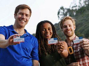 three people holding up aaa membership cards