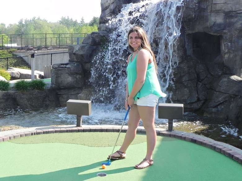 a young woman posing before hitting golf ball