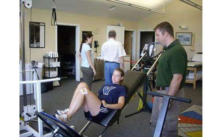 Girl exercising with therapist instructing her