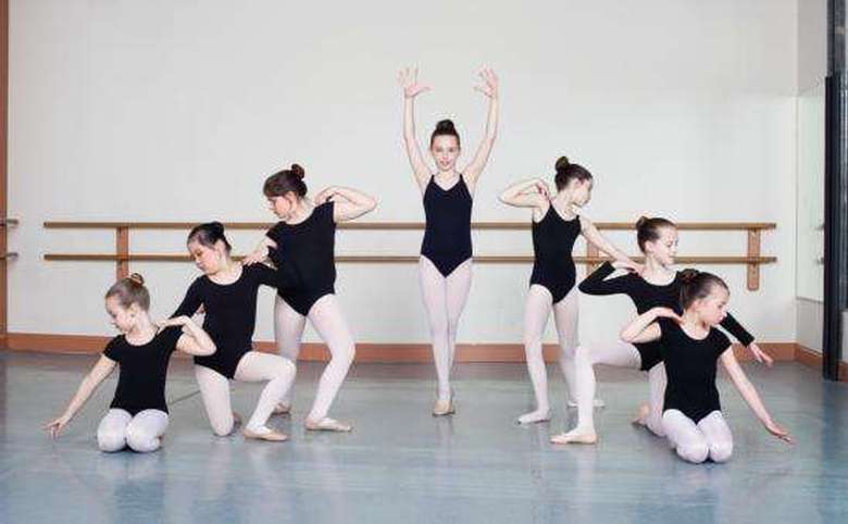7 girls posing, one in the center and the others creating an arc around her