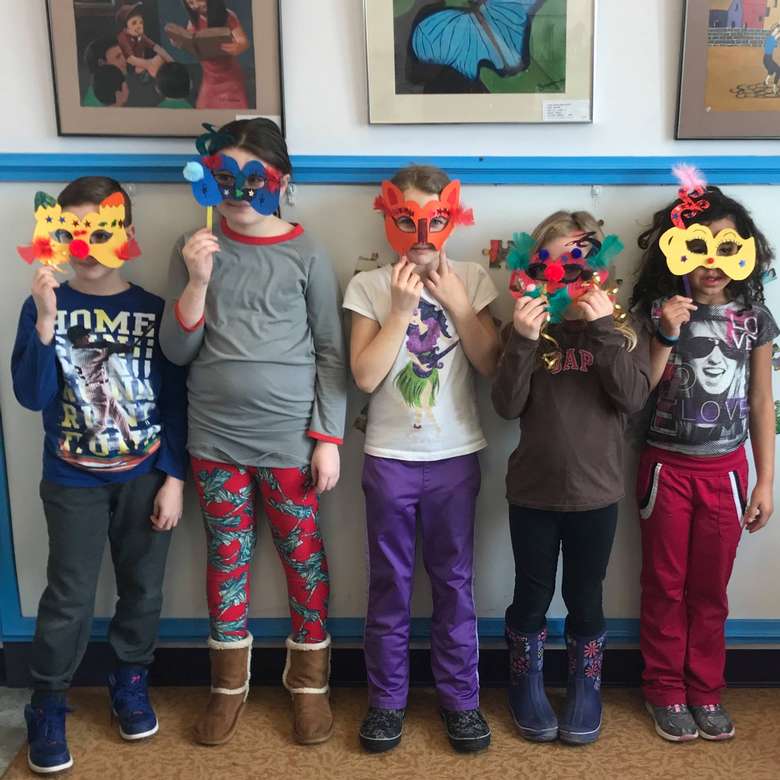 five kids holding homemade masks over their faces