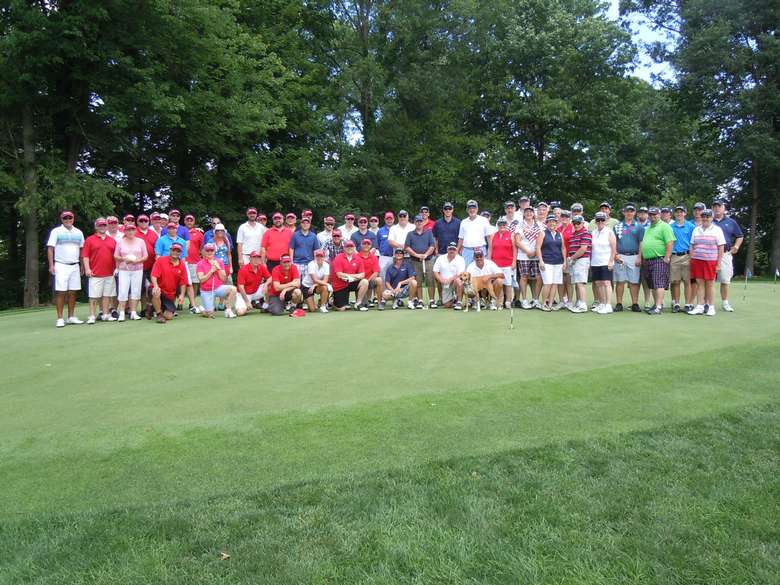 large group of golfers posing before a tournament