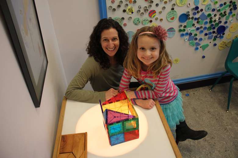 mother and daughter playing with puzzle pieces