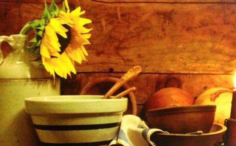 a sunflower in a jug with other kitchenware