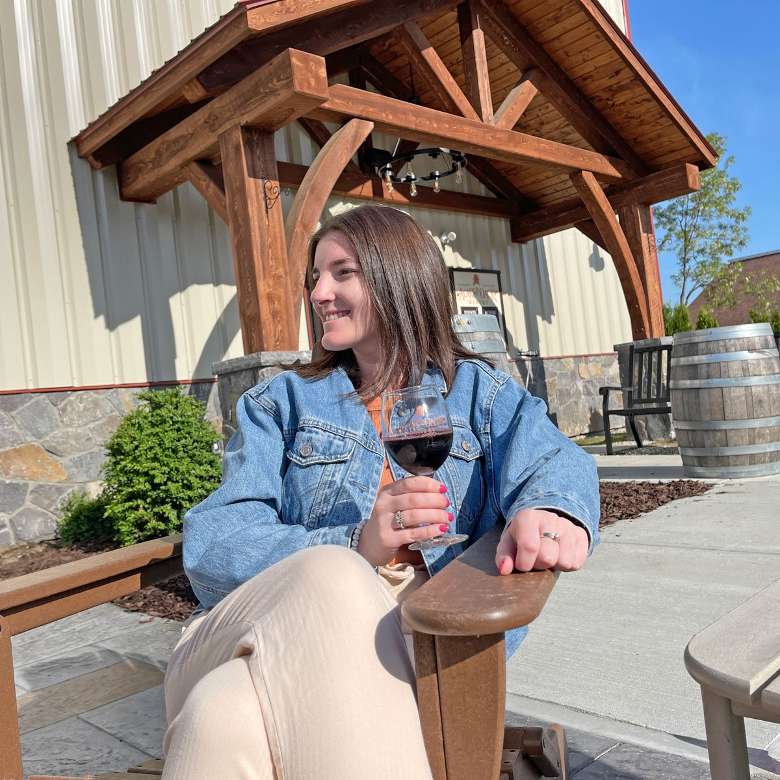 Visit the website and book a tasting today! woman on patio with glass of wine