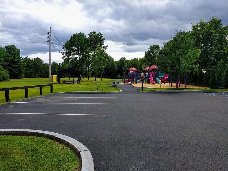a parking lot at a park near a playground