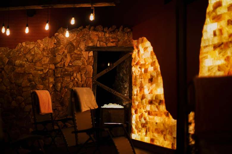 man-made salt cave with lounge chairs and salt blocks on the walls