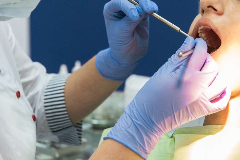 a dentist checking out a patient's mouth with a tool