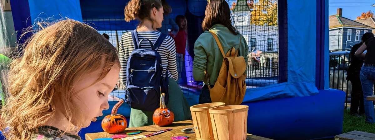 little girl decorates pumpkin