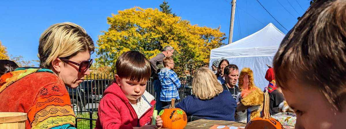 little boy decorates pumpkin