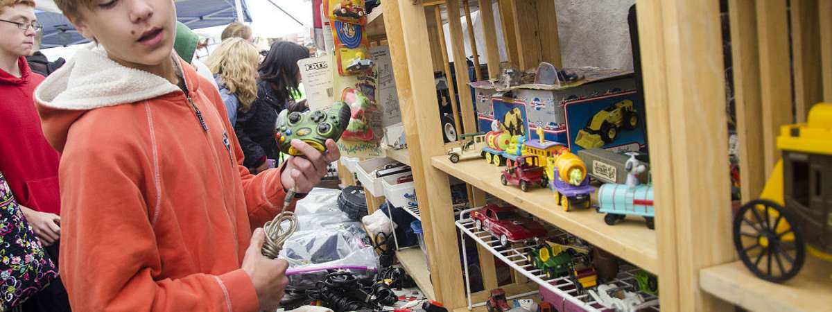 boy browsing toys at garage sale