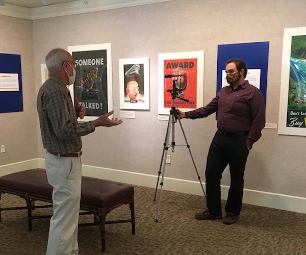 two men standing inside the Chapman Museum wearing masks