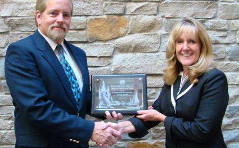 Woman and man shaking  hands holding award