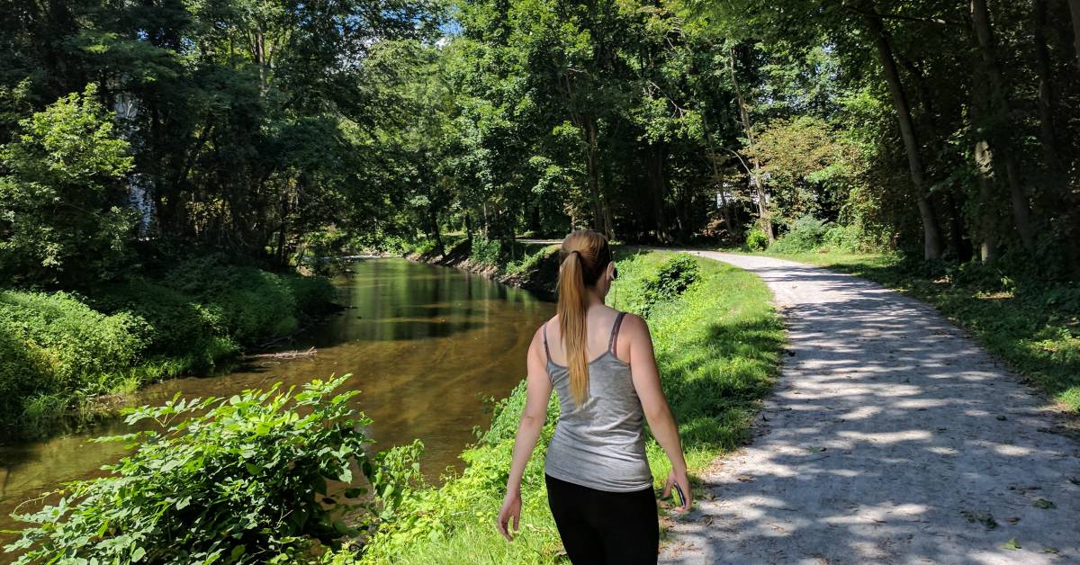 woman walks on feeder canal path