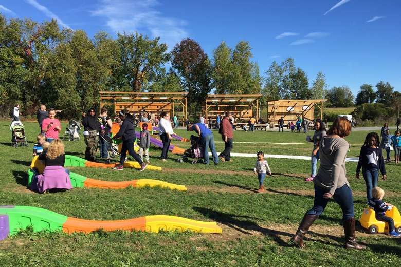 young kids playing on small non-motorized roller-coasters