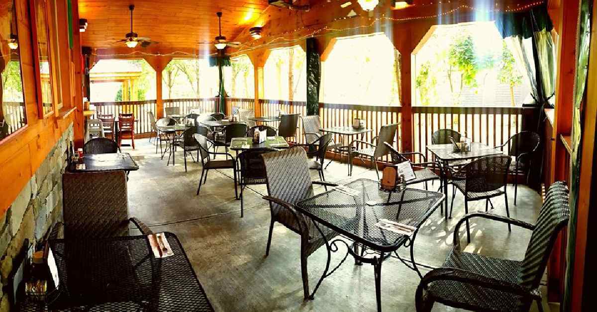 tables and chairs underneath a covered patio