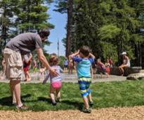 dad with kids at splash pad in crandall park