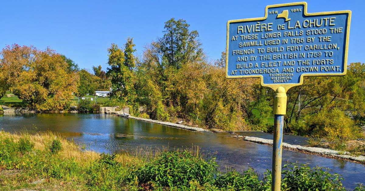 rivere de la chute sign by river and fall foliage