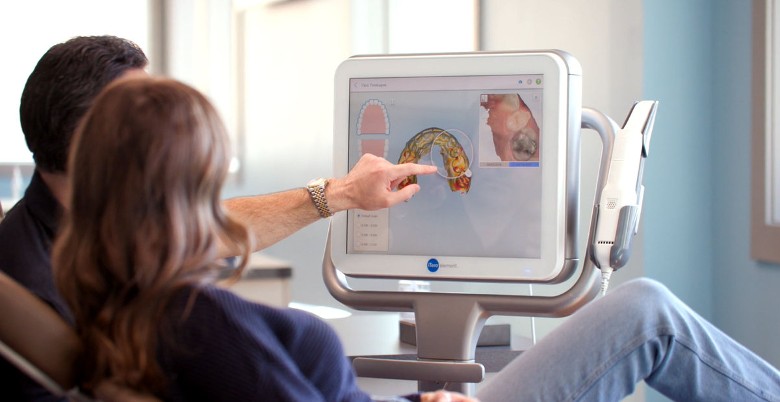orthodontist pointing at screen for patient