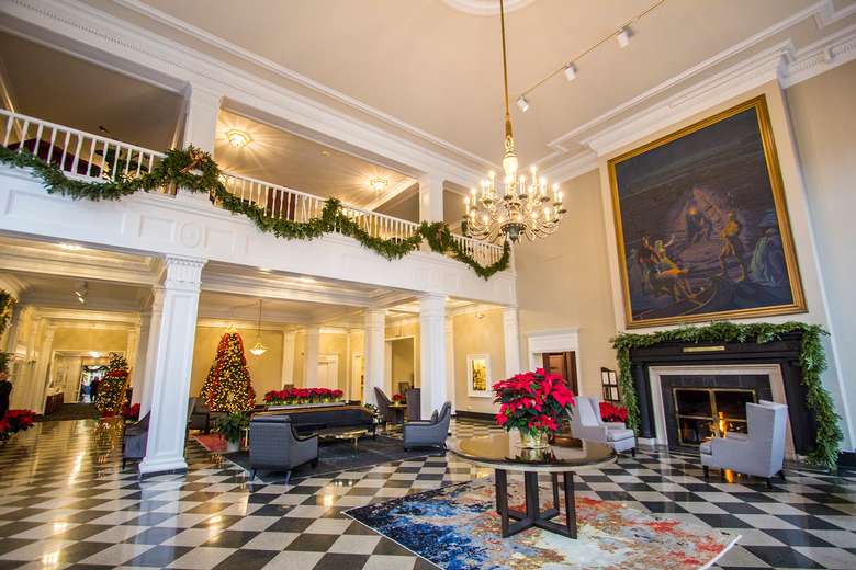 lobby at the queensbury decorated for the holidays with poinsettias and garlands