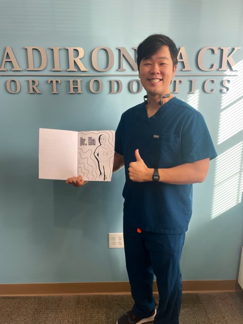 orthodontist holding up a booklet