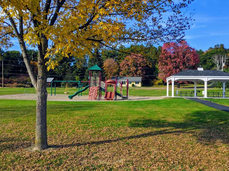 playground and picnic tables under gazebo structure in fall