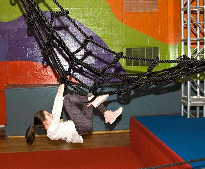a girl climbing up a net