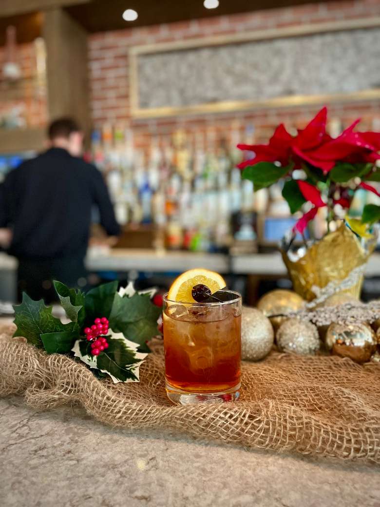 Check out the craft cocktail menu. bourbon cocktail in front of a bar