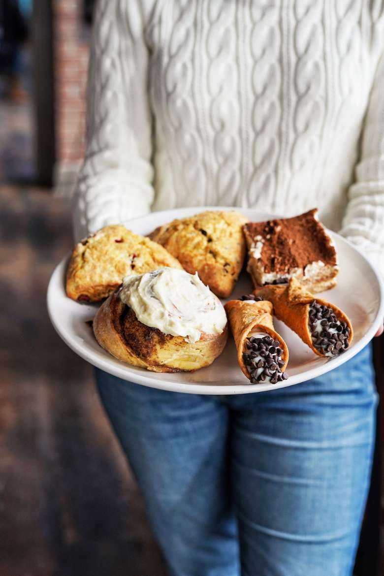 Take advantage of fast-casual breakfast and lunch, and house-made desserts and baked goods. baked items on a plate being carried