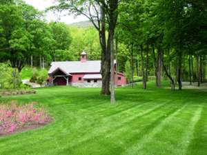 park with a new sod lawn and a red building in the background