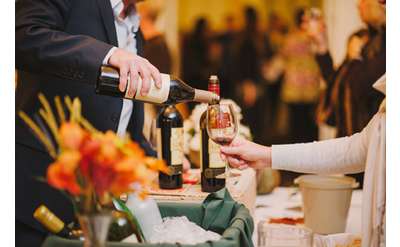 man pouring wine at a tasting