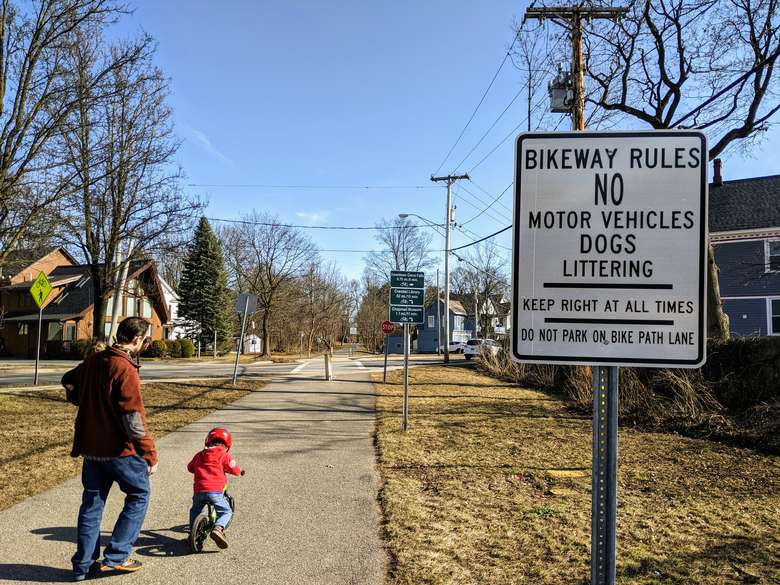 man and child on bike path with no motor vehicles sign