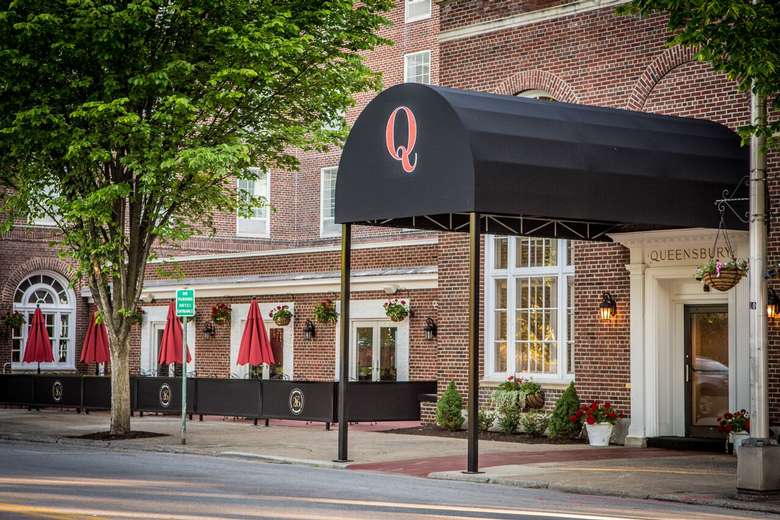 black awning with a red Q on it in front of an entrance to the queensbury hotel