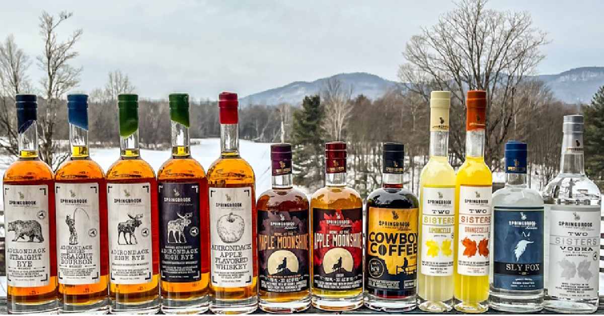 several bottles of spirits in front of a winter mountain landscape 