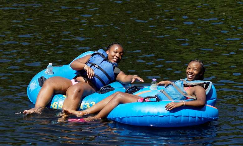two girls hanging out in blue tubes on a river