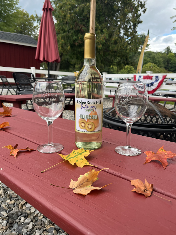 Wine bottle and wine glass amongst fall leaves